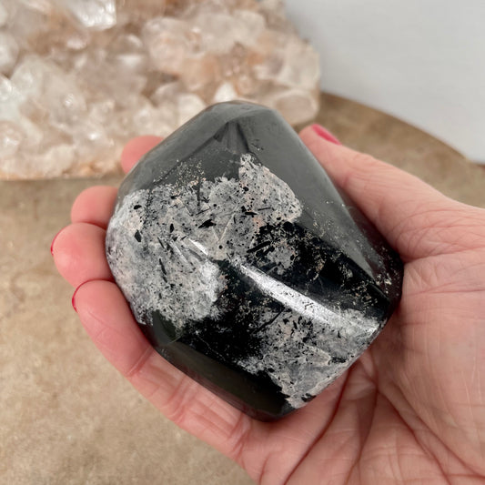 Black Tourmaline Free Form  in the palm of a hand.