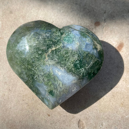 Moss Agate Heart on Stone Background
