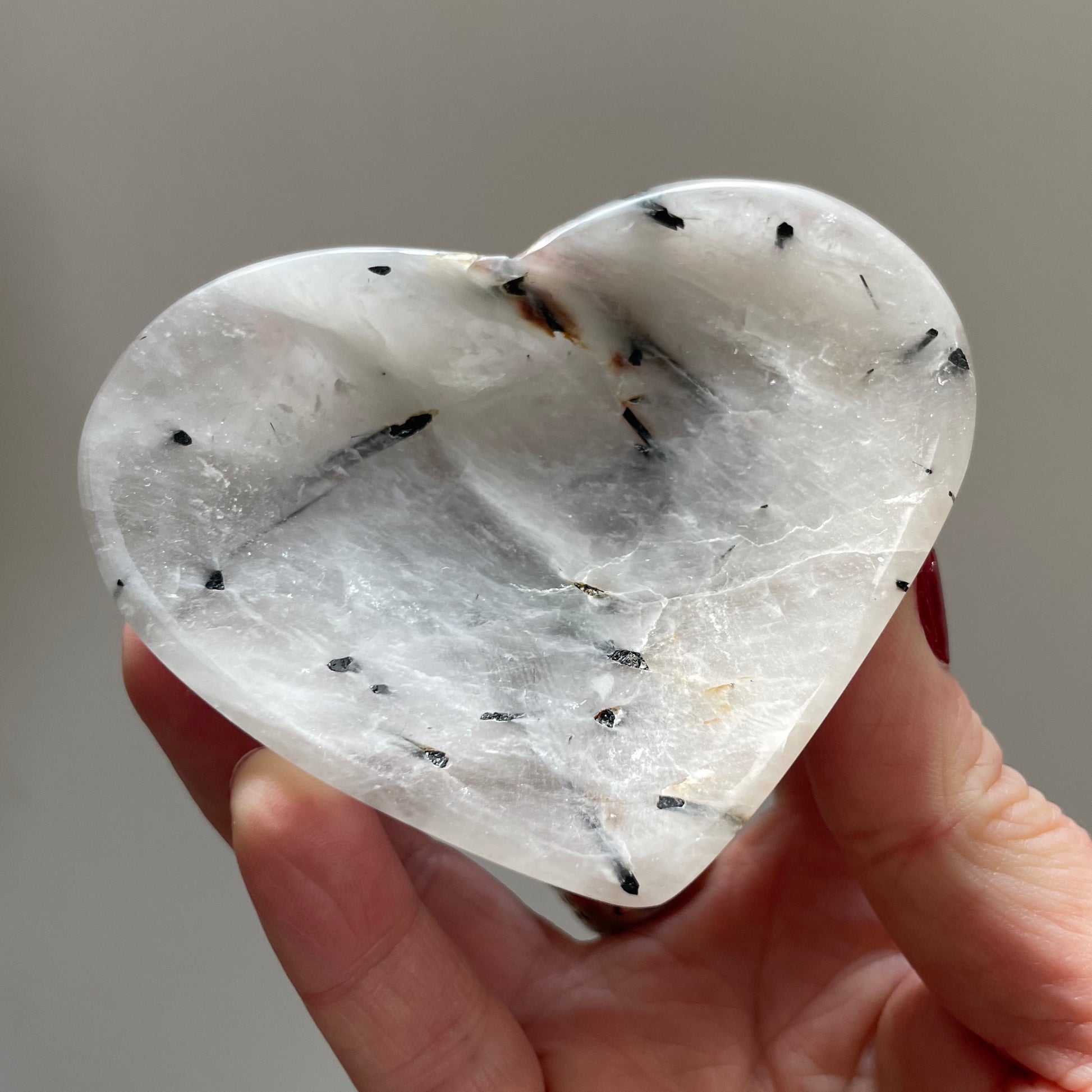 A hand holding Tourmaline Quartz Heart Bowl 8cm.
