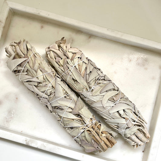 Two White Sage Sticks sitting in a box.
