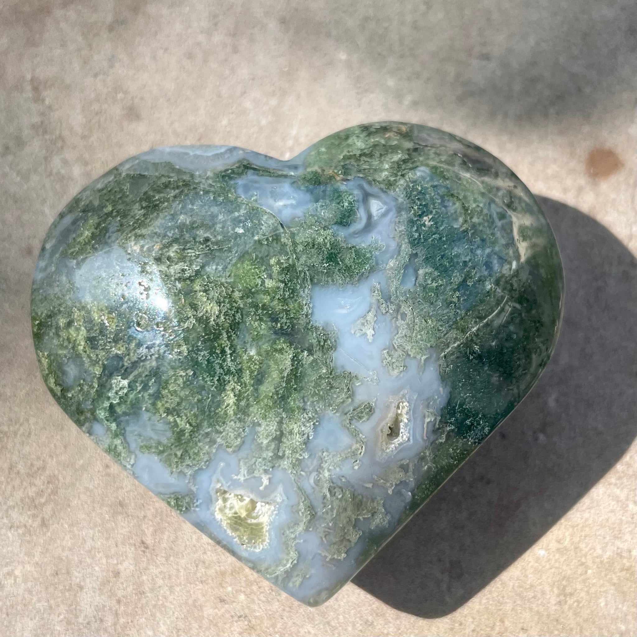 Moss Agate heart on stone background
